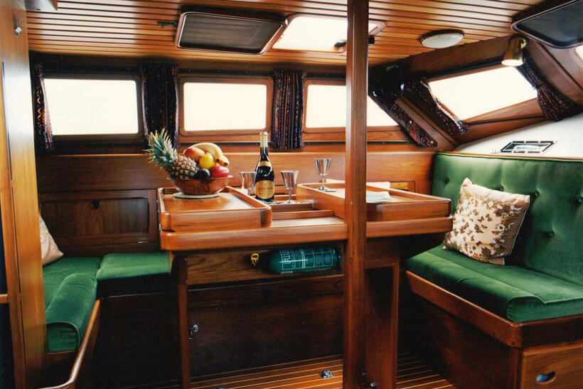 Saloon. The freezer is located below the table, and large storage lockers which extend out to the hull are under all settees.